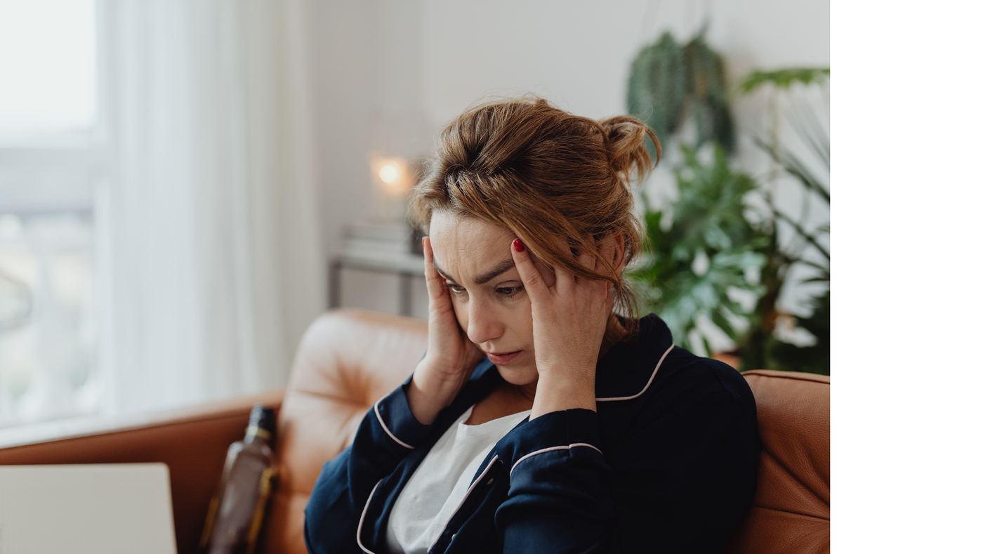 Erschöpfte Frau auf einer Couch – Symbolbild für chronischen Stress